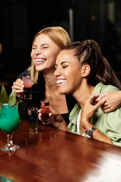 Two young colleagues enjoy laughs and drinks at a festive corporate gathering. — Stock Photo