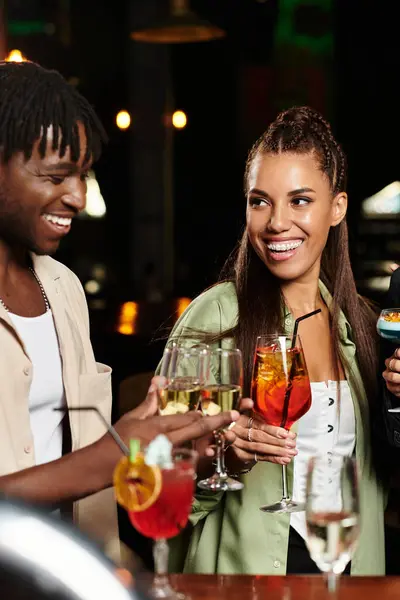 At a vibrant corporate party, young professionals raise their glasses in joyful celebration. — Stock Photo