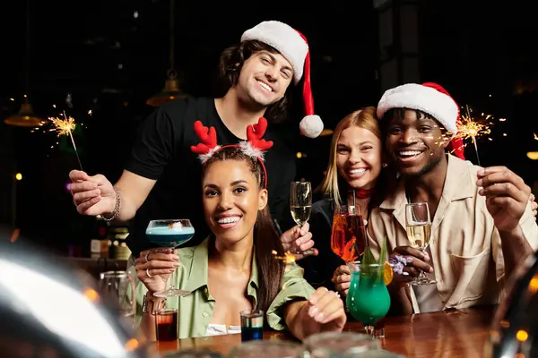 Colleagues enjoy a lively corporate celebration with drinks, laughter, and festive hats. — Stock Photo