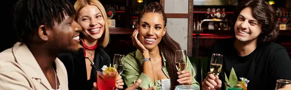 In a lively atmosphere, young professionals celebrate teamwork with drinks and smiles together. — Stock Photo