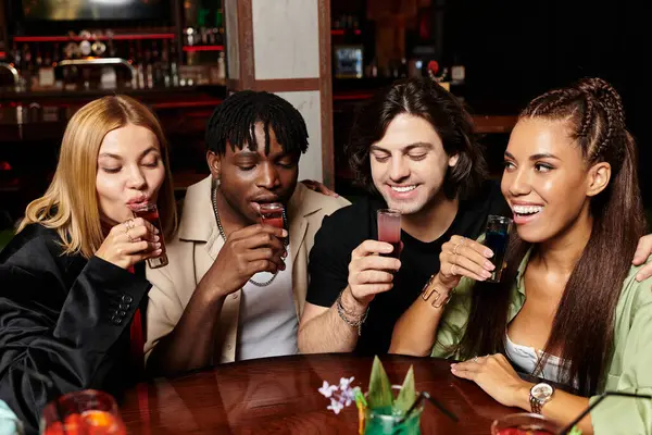 Un groupe de jeunes collègues célèbre avec des boissons colorées lors d'une réunion d'entreprise animée. — Photo de stock