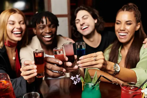 Um encontro vibrante onde os colegas riem e brindam com bebidas coloridas, aproveitando o momento. — Fotografia de Stock