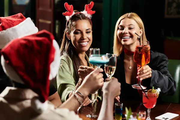 Colleagues raise colorful cocktails in celebration at a lively corporate holiday gathering. — Stock Photo