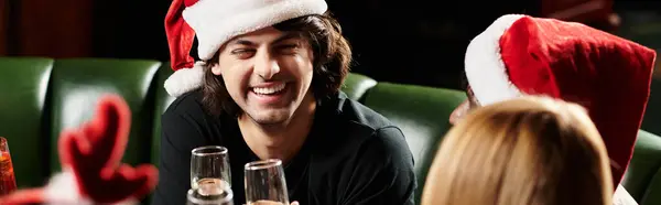 Diverse young professionals enjoy a joyful corporate celebration while wearing festive hats. — Stock Photo