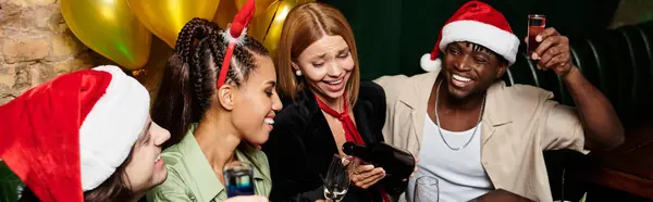 Un groupe de jeunes collègues célèbrent avec des boissons et des rires lors d'une fête de vacances animée. — Photo de stock