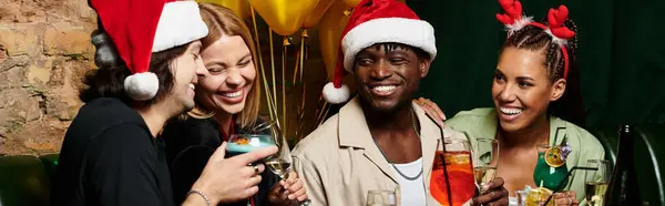 Young professionals share smiles and drinks at a lively holiday gathering, enjoying the atmosphere. — Stock Photo