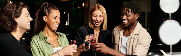 A group of young professionals enjoys drinks, laughing and toasting at a corporate celebration. — Stock Photo