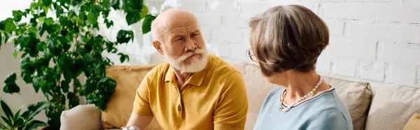 A senior couple enjoys a heartfelt moment at home, focusing on health and support together. — Stock Photo