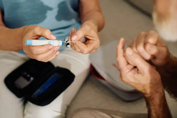A loving wife supports her husband as he manages diabetes at home, showing compassion and care. — Stock Photo