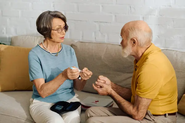 Una moglie dedicata sostiene il marito con il diabete nel loro accogliente soggiorno a casa. — Stock Photo