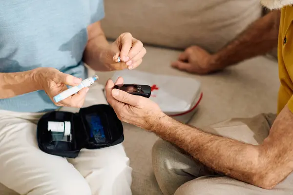 Una moglie devota aiuta il marito a gestire il suo diabete nel comfort della loro casa. — Foto stock