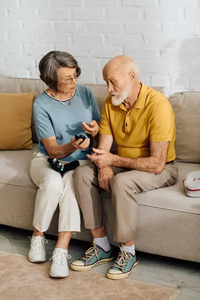 A devoted wife helps her husband manage his diabetes at home, showing love and care. — Stock Photo