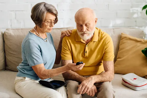 A devoted wife supports her husband as they manage his diabetes in a cozy home setting. — Stock Photo