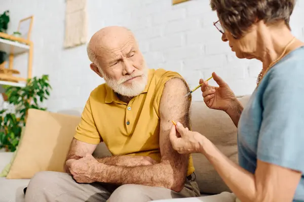 A devoted wife helps her husband manage diabetes by giving him an important injection at home. — Stock Photo