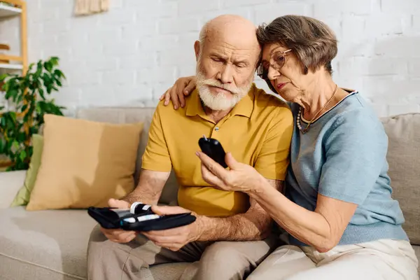 A devoted wife helps her husband monitor his diabetes while they sit together comfortably. — Stock Photo