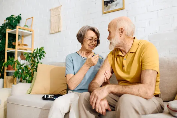 A loving wife gently assists her husband who has diabetes, showcasing their bond at home. — Stock Photo