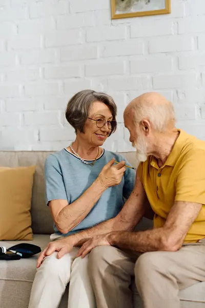 A senior couple enjoys a warm moment at home the wife supports her diabetic husband. — Stock Photo