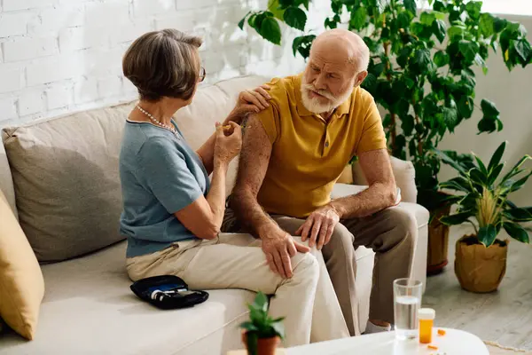 Eine liebevolle Ehefrau hilft ihrem an Diabetes erkrankten Mann, während sie bequem zu Hause sitzen. — Stockfoto