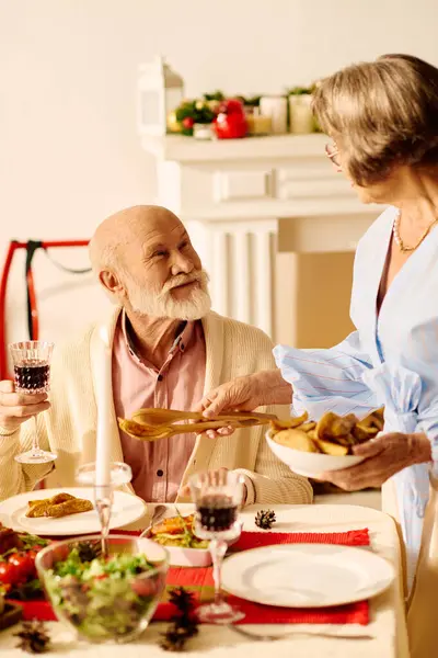 A senior couple shares laughter and love while preparing for their Christmas dinner at home. — Stock Photo