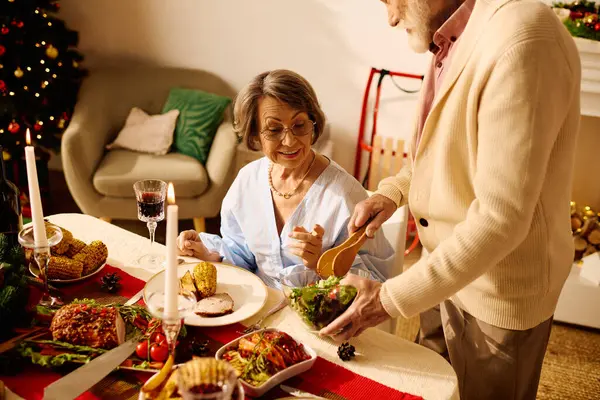 A loving senior couple shares a delightful Christmas meal together, filled with warmth and joy. — Stock Photo