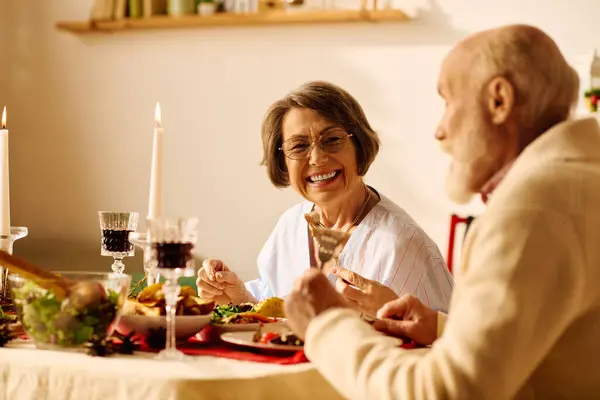 Una coppia anziana gioiosa si gode una cena di Natale a casa. — Foto stock
