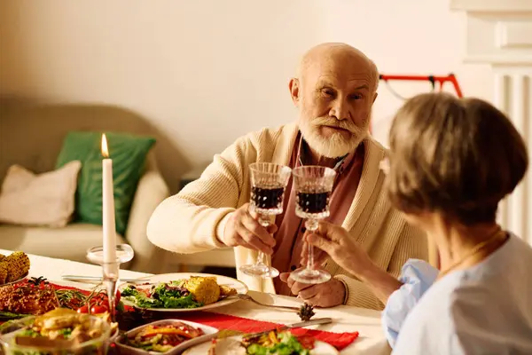 A senior couple enjoys a heartfelt toast during their cozy Christmas celebration at home. — Stock Photo