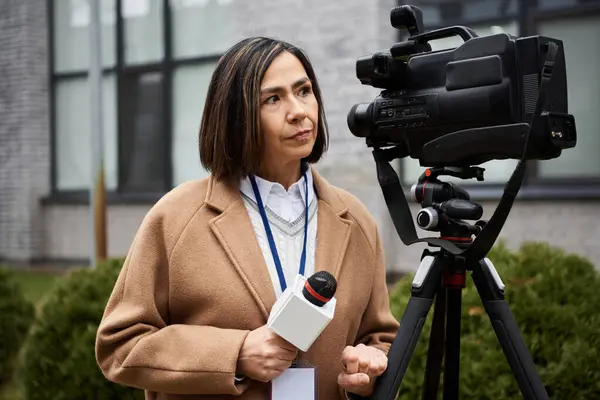 Un giornalista dedicato si prepara per un'intervista, microfono in mano, trasudando fiducia in un evento di notizie. — Foto stock