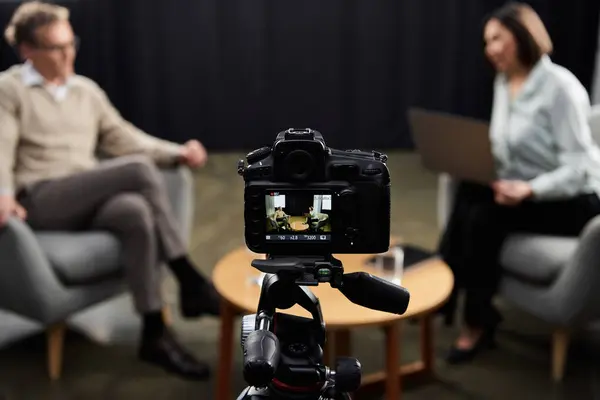 A journalist engages with a specialist in a thoughtful discussion, capturing insights in a professional setting. — Stock Photo