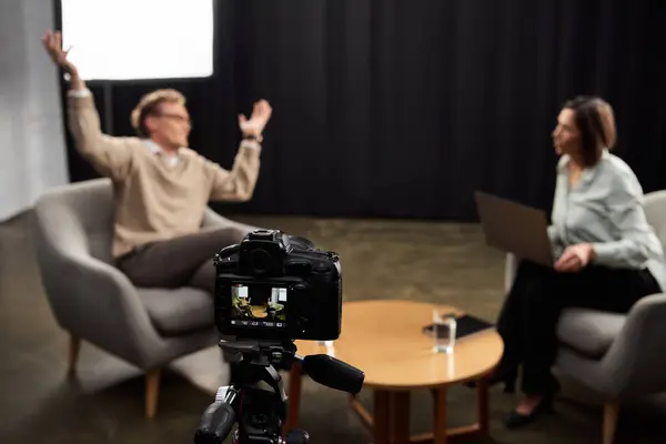 A professional journalist conducts an engaging interview with a specialist in a modern studio environment. — Stock Photo