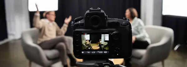 A professional journalist engages in a thoughtful discussion with a male expert, capturing key insights. — Stock Photo