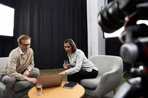 A middle-aged journalist engages with a specialist in a professional studio, discussing important topics. — Stock Photo