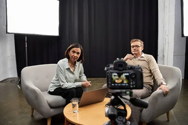 Un giornalista di mezza età intervista uno specialista di sesso maschile in uno studio elegante, catturando un dialogo profondo. — Foto stock