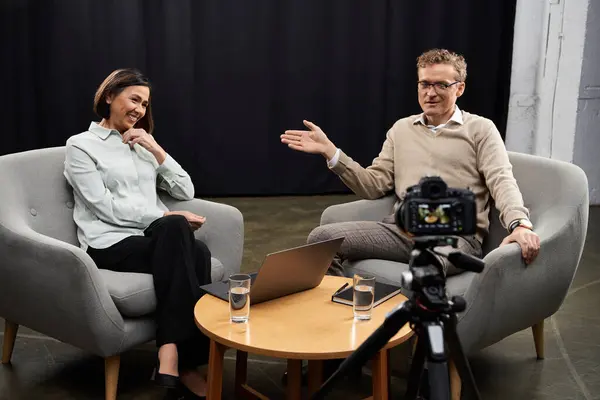 Eine Journalistin mittleren Alters trifft einen männlichen Experten in einer professionellen Gesprächsatmosphäre. — Stockfoto