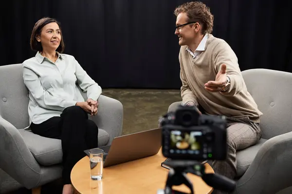 A middle-aged journalist conducts an insightful interview with a male specialist in a comfortable studio setup. — Stock Photo