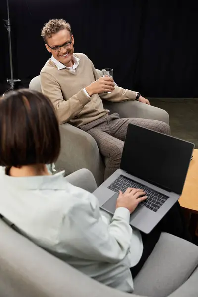 Ein erfahrener Journalist verwickelt einen Spezialisten mit einem Laptop in ein nachdenkliches Gespräch. — Stockfoto