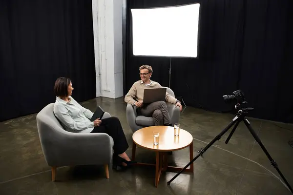 A middle-aged journalist engages in an insightful discussion with a specialist, sharing expertise. — Stock Photo