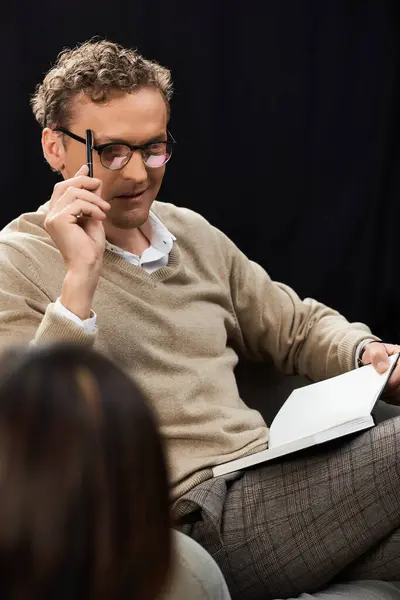 A journalist attentively interviews a professional woman, taking notes and asking thoughtful questions. — Stock Photo