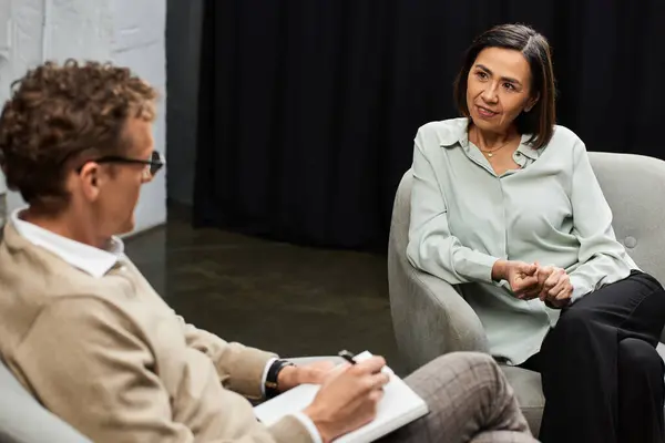 A journalist in a cozy studio engages with a specialist, uncovering her insights and professional expertise. — Stock Photo