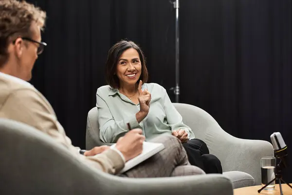 Um jornalista entrevista um especialista em um estúdio brilhante, compartilhando insights e participando de uma discussão animada. — Fotografia de Stock