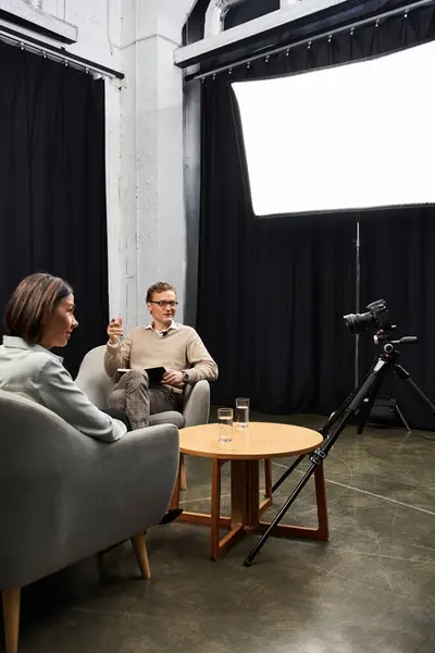 Um jornalista e um especialista profissional compartilham insights durante uma entrevista em um estúdio elegante. — Fotografia de Stock