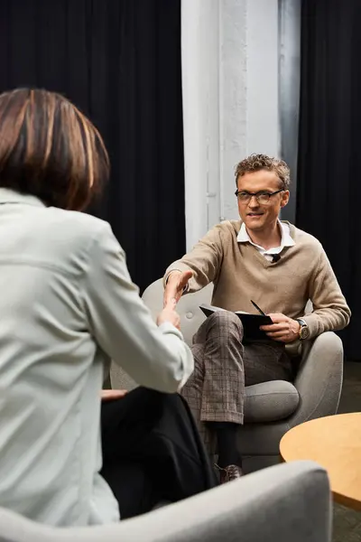 A journalist conducts a focused interview with a specialist, capturing insights in a contemporary environment. — Stock Photo