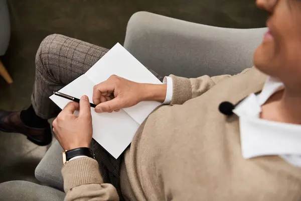A journalist is engaged in a deep conversation, taking notes attentively. — Stock Photo