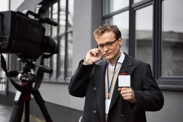 A dedicated journalist holds a microphone, preparing for an important live report during a rainy day. — Stock Photo