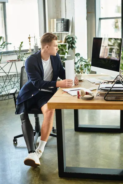 Um homem de negócios jovem e bonito com uma perna protética se concentra em seu trabalho em um ambiente de escritório elegante. — Fotografia de Stock