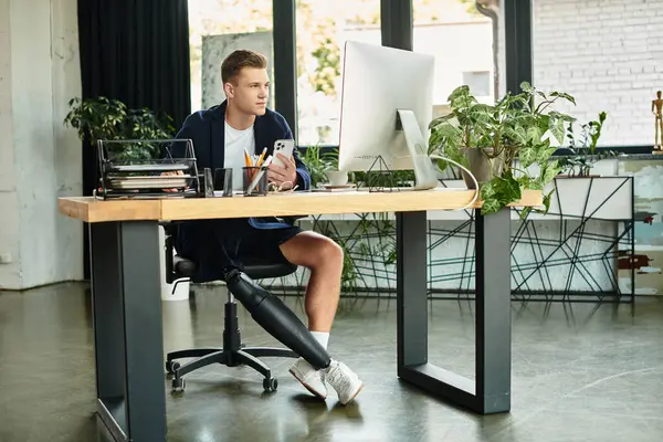 A young professional with a disability works diligently in a stylish, contemporary office environment. — Stock Photo