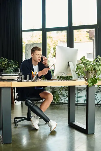 A determined young businessman with an artificial limb excels in his sleek office, demonstrating inclusion. — Stock Photo