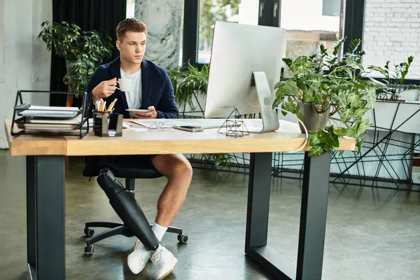 A young businessman with a prosthetic leg engages in work at a contemporary office setting filled with greenery. — Stock Photo