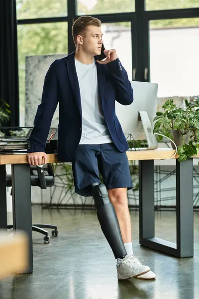 Um homem de negócios jovem e elegante com uma perna protética está trabalhando em um ambiente de escritório contemporâneo. — Fotografia de Stock