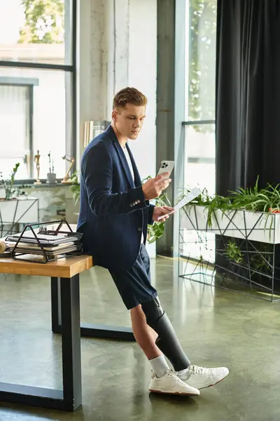 A young professional with an artificial limb is engaged in work at a stylish office, showcasing inclusion. — Stock Photo