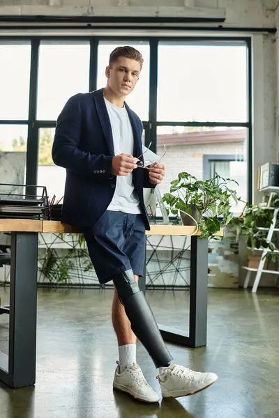 A young businessman shows determination as he works in a stylish office, showcasing inclusion and resilience. — Stock Photo